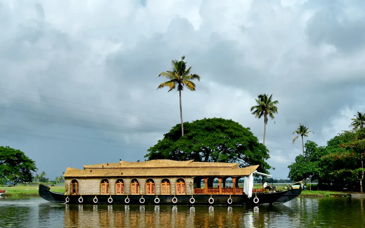 A houseboat floating beside palms on Kerala's backwaters