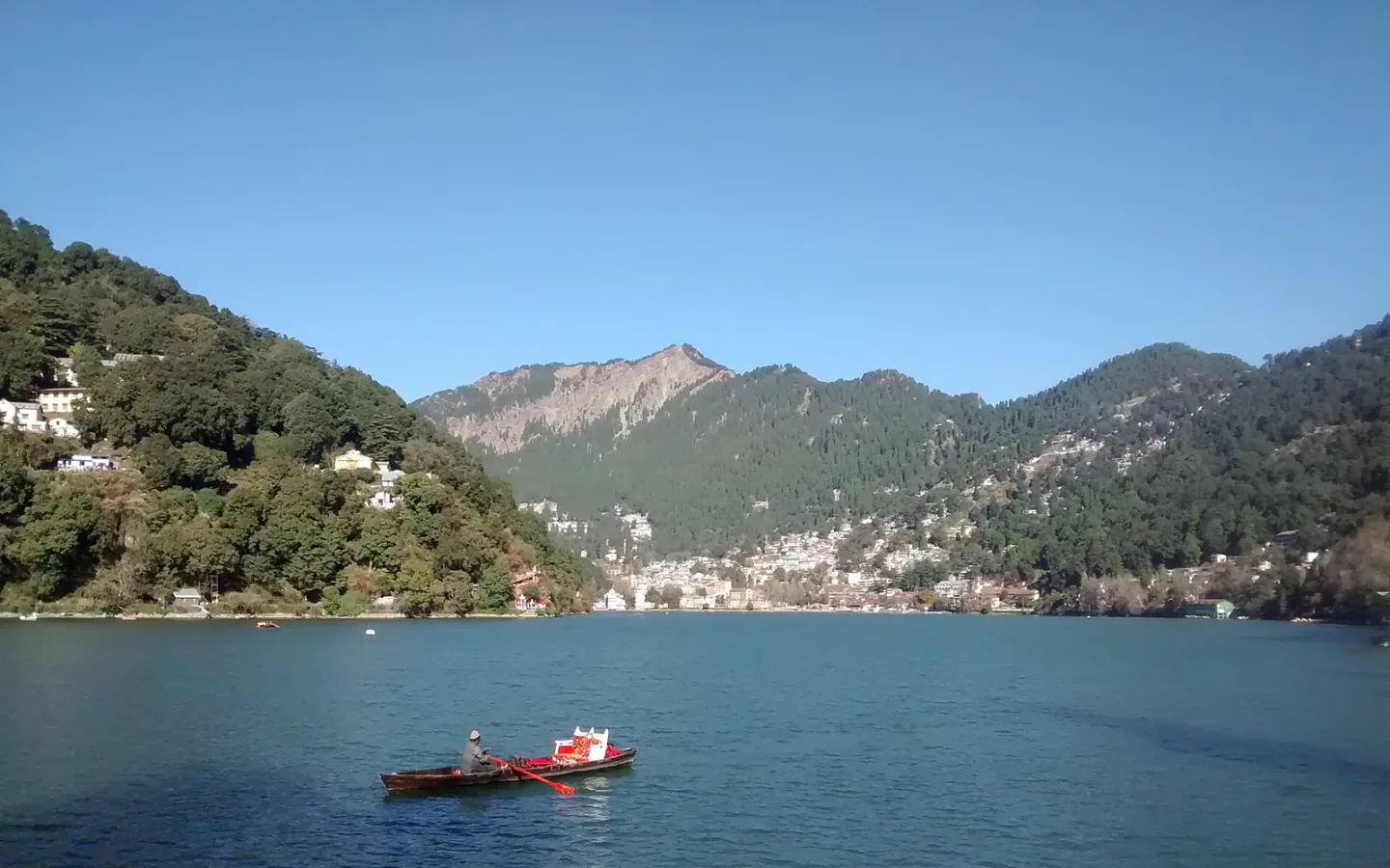 A boat on Nainital Lake with the town and hills beyond